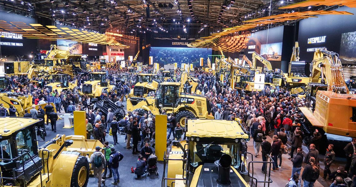 Messehalle mit Besuchern und Baumaschinen von Caterpillar