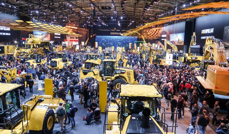 Messehalle mit Besuchern und Baumaschinen von Caterpillar