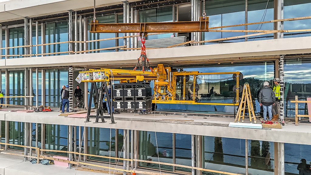Präzise Glasmontage mit zwei Baukranen (Bild: Heavydrive)