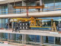 Präzise Glasmontage mit zwei Baukranen